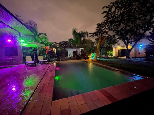 a swimming pool at night with purple and green lights at Pyramid Tamarindo Luxury Hotel in Tamarindo