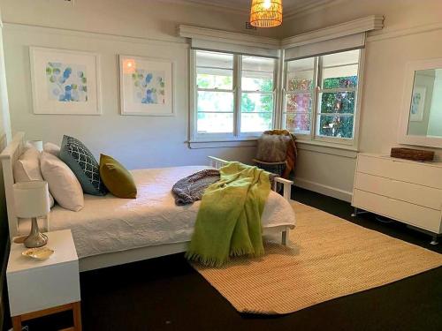 a bedroom with a large bed with green pillows at Golden Square Gold Class Guest House, Bendigo in Golden Square