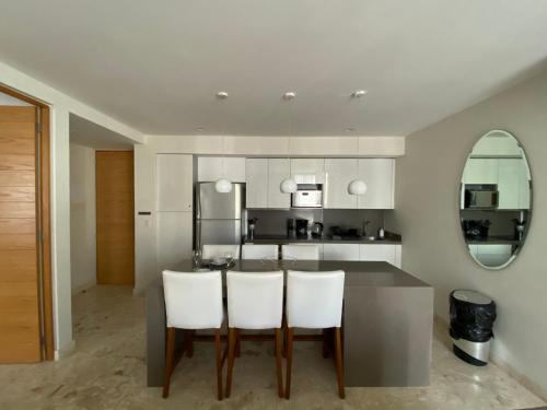 - une cuisine avec une table et des chaises blanches dans l'établissement Departamento 2 recámaras Anah, à Playa del Carmen