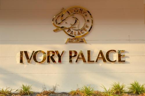 a sign that reads money palace hanging on a wall at Ivory Palace Hotel in Pattaya