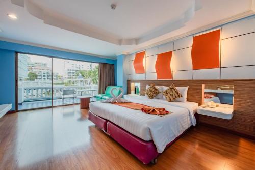 a bedroom with a large bed and a large window at Caesar Palace Hotel in Pattaya
