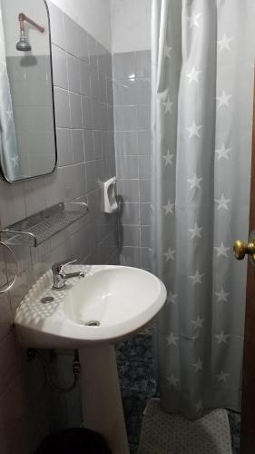 a bathroom with a sink and a shower curtain with stars at La Casa de Teresa in Colonia del Sacramento
