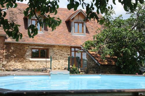une piscine devant une maison dans l'établissement B&B Le Relais de Chantecor, à La Coquille
