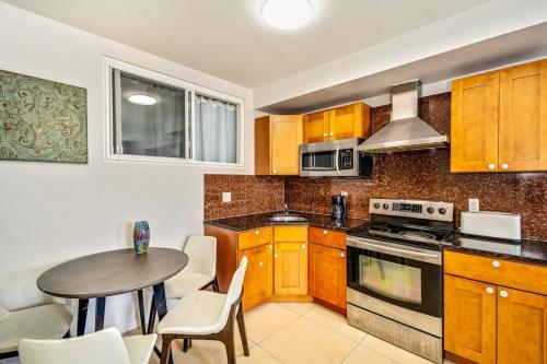 a kitchen with wooden cabinets and a table with chairs at Forget the Hotel and stay in Style in a 2bd Apt in Philadelphia