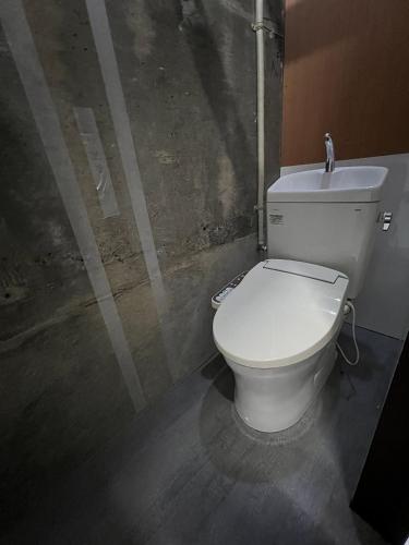a bathroom with a white toilet in a room at Apple-garage in Mitoyo
