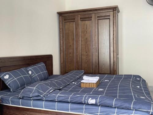 a bed with blue sheets and a wooden headboard at An Bungalow - Mai Châu in Hòa Bình