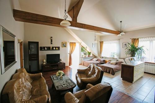 a living room with couches and a tv at Gościniec Marzymięta in Czmoń