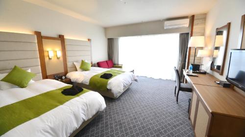 Satsuma Resort Hotel في Satsuma: غرفة فندقية بسريرين وتلفزيون بشاشة مسطحة