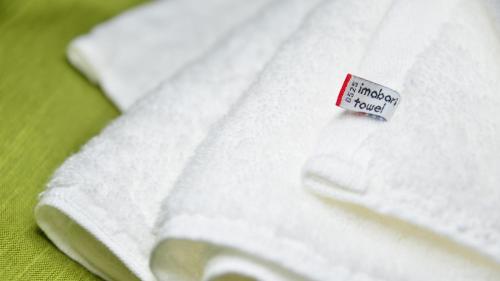 a white towel with a tag on it on a bed at Satsuma Resort Hotel in Satsuma