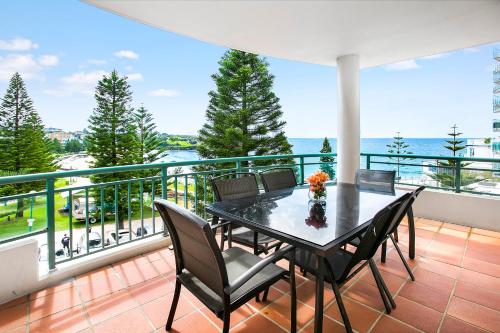 a balcony with a table and chairs and the ocean at The Coogee View Beachfront Serviced Apartments in Sydney