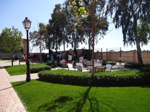 a park with chairs and a street light and trees at Hotel Comendador in Carranque