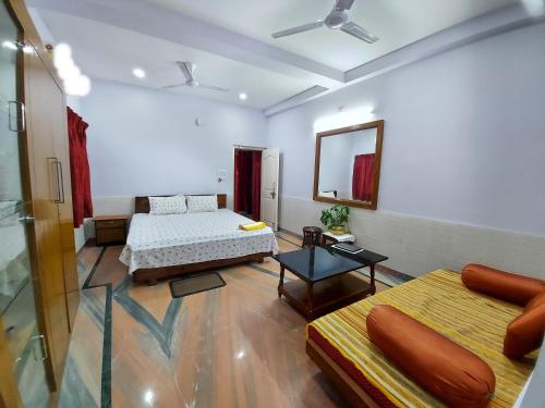 a large room with two beds and a mirror at Chaiti Eco Homestay- Santiniketan Bolpur in Bolpur