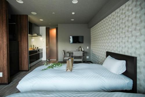 a bedroom with a large bed and a table at Vacation Rent 金沢 in Kanazawa