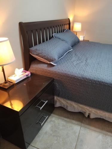 a bedroom with a bed and a night stand with a lamp at Cabañas Los Laureles ruta del vino in Ensenada