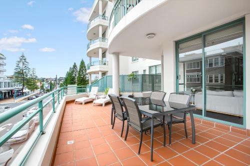 a balcony with a table and chairs on a building at The Coogee View Beachfront Serviced Apartments in Sydney