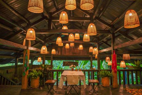 a dining room with a table and chandeliers at P'apiu Resort in Ha Giang