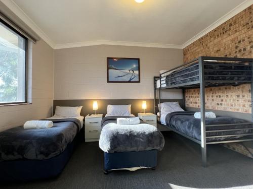 a room with three bunk beds in it at Yuki Inn Jindabyne in Jindabyne