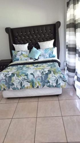 a bedroom with a bed with blue and white sheets at 26 Zea avenue Arcon Park Guest House in Vereeniging
