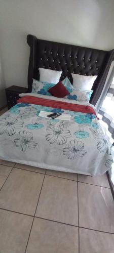 a bed with a black and white comforter on it at 26 Zea avenue Arcon Park Guest House in Vereeniging
