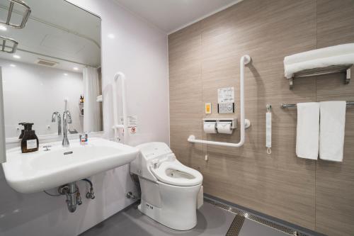 a bathroom with a sink and a toilet and a mirror at Rembrandt Style Naha in Naha