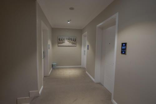 an empty hallway with white walls and a painting on the wall at Sweet Light Serviced Apartments in Tabuk