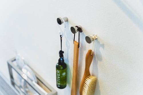 a wall with two tooth brushes and a bottle on it at Rembrandt Style Naha in Naha