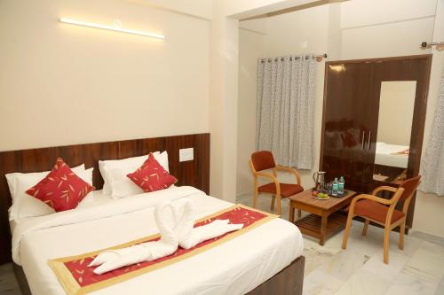 a hotel room with a bed and a table and chairs at Soundarya Hotel in Bengaluru
