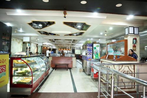 a fast food restaurant with a counter and people in it at Soundarya Hotel in Bengaluru