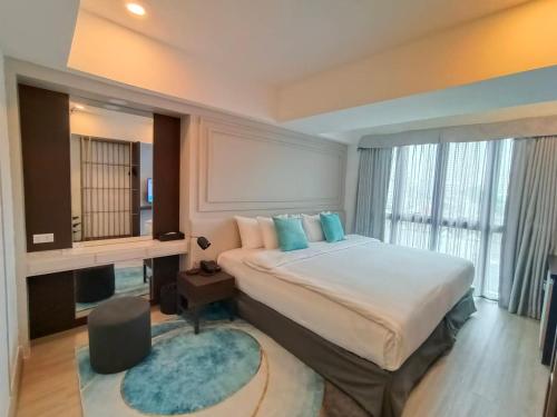 a bedroom with a large bed and a large window at VIVA LA VIDA HOTEL in Bangkok