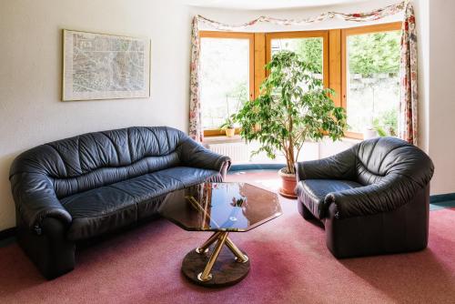 a living room with two leather couches and a table at Hotel Bärolina in Serfaus