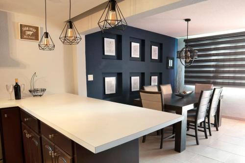 Clean&Equipped, 1-Floor 3-Bedroom Downtown House في إنسينادا: مطبخ وغرفة طعام مع طاولة وكراسي