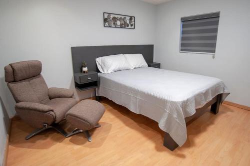 - une chambre avec un lit et deux chaises dans l'établissement Clean&Equipped, 1-Floor 3-Bedroom Downtown House, à Ensenada