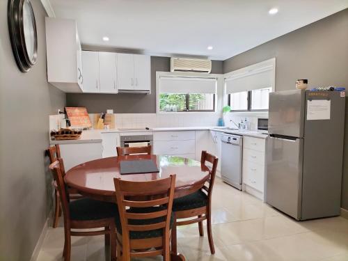 a kitchen with a table and chairs and a refrigerator at Eureka Views B&B Ballarat in Ballarat