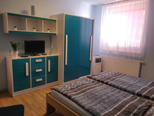 ein Schlafzimmer mit einem Bett und einem blauen Schrank in der Unterkunft Penzion u Mikulinců in Mikulov