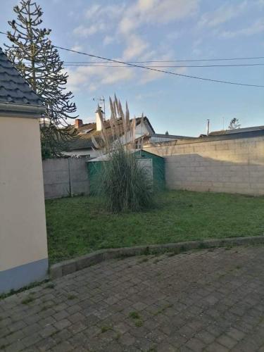une cour avec un mur en briques et une clôture dans l'établissement Le pied à terre, à Feuquières-en-Vimeu
