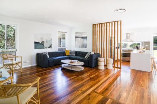 a living room with a couch and a table at Blissful Bungalow in Culburra Beach