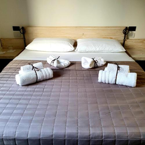 a large bed with four pillows and towels on it at Camere Fiera Verona - CasaNostra in Verona
