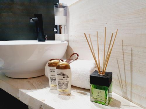 a bathroom with a sink and a counter with two products at Camere Fiera Verona - CasaNostra in Verona