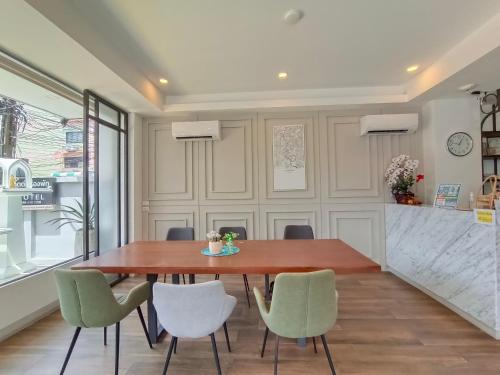 a dining room with a wooden table and chairs at VIVA LA VIDA HOTEL in Bangkok