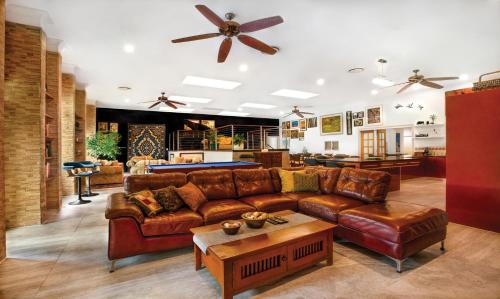 a living room with a leather couch and a pool table at Luxury Penthouse 5 BDR 3 Bath Twin Rain Showers 365 sq mtrs in Port Douglas