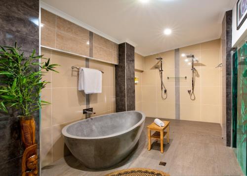 een badkamer met een groot bad en een douche bij Luxury Penthouse 5 BDR 3 Bath Twin Rain Showers 365 sq mtrs in Port Douglas