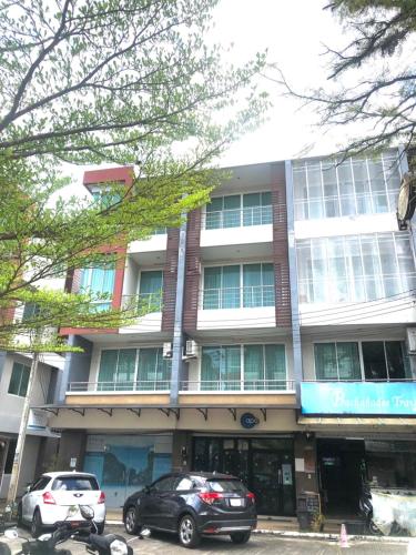 a building with cars parked in front of it at Apo Hotel in Krabi town