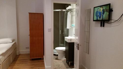 La salle de bains est pourvue d'un lavabo et de toilettes. dans l'établissement Shepherd's Bush Flats, à Londres