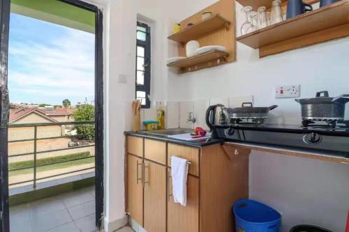 a kitchen with a view of a balcony at Lux Suites Rio Vista Executive Studio Apartments in Makandara