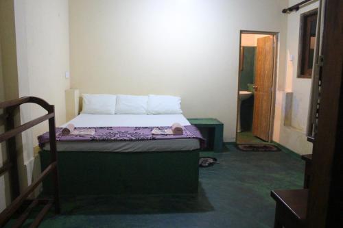 ein kleines Schlafzimmer mit einem Bett in einem Zimmer in der Unterkunft sinharaja Aranuwa resort in Nelluwa