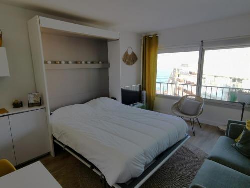 une chambre avec un lit, un canapé et une fenêtre dans l'établissement L'Estacade, à Les Sables-dʼOlonne