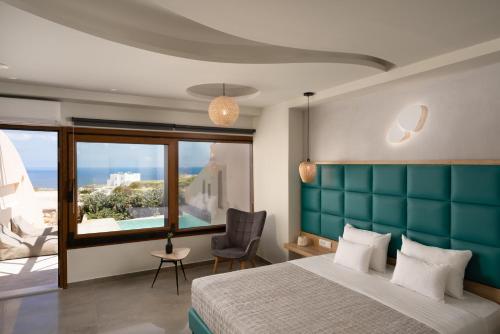 a bedroom with a large bed with a blue headboard at Perla Nera Suites in Fira