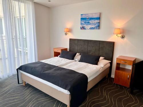 a bedroom with a large bed in a room with windows at Holiday Resorts in Balatonszárszó