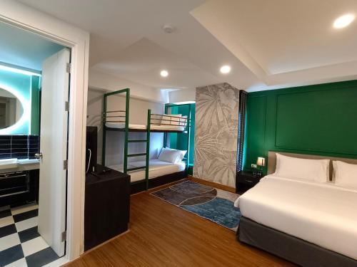 a bedroom with a bed and a green wall at VIVA LA VIDA HOTEL in Bangkok