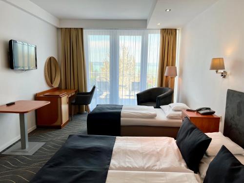 a hotel room with two beds and a desk at Holiday Resorts in Balatonszárszó
